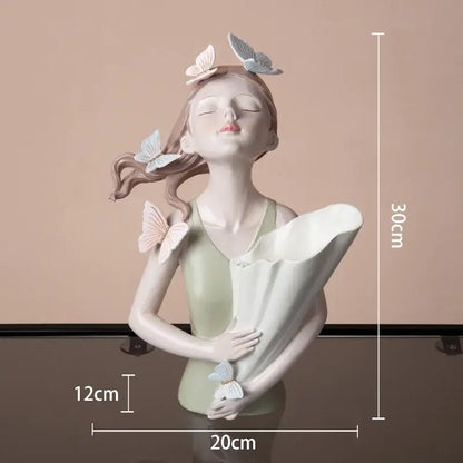 Delicate modern pink butterfly girl sculpture in resin featuring pastel butterflies holding a white scroll decorbites butterfly girl