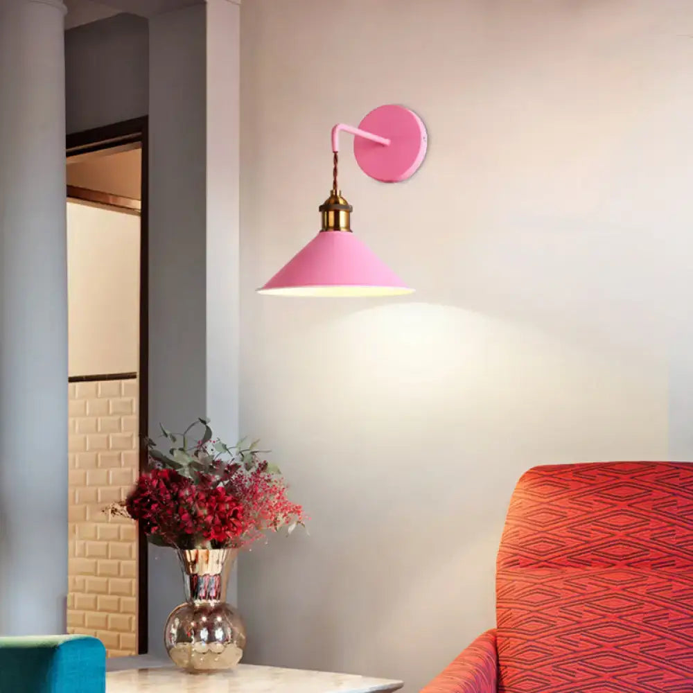Modern pink conical metal wall sconce with brass-finished mounting plate ideal for gray pink hallway lighting