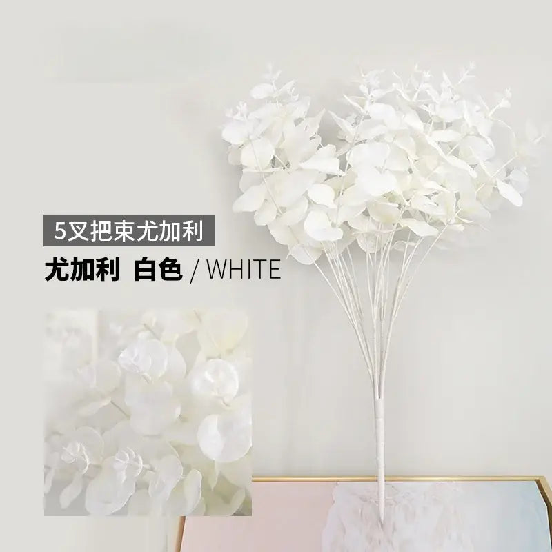Modern pink eucalyptus flower arrangement featuring a white artificial eucalyptus flower with round leaves in a glass vase
