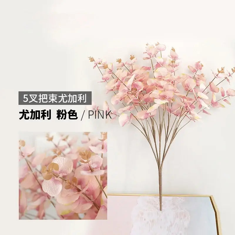 Modern pink eucalyptus flower arrangement with delicate soft rounded leaves in a glass vase for living room decor