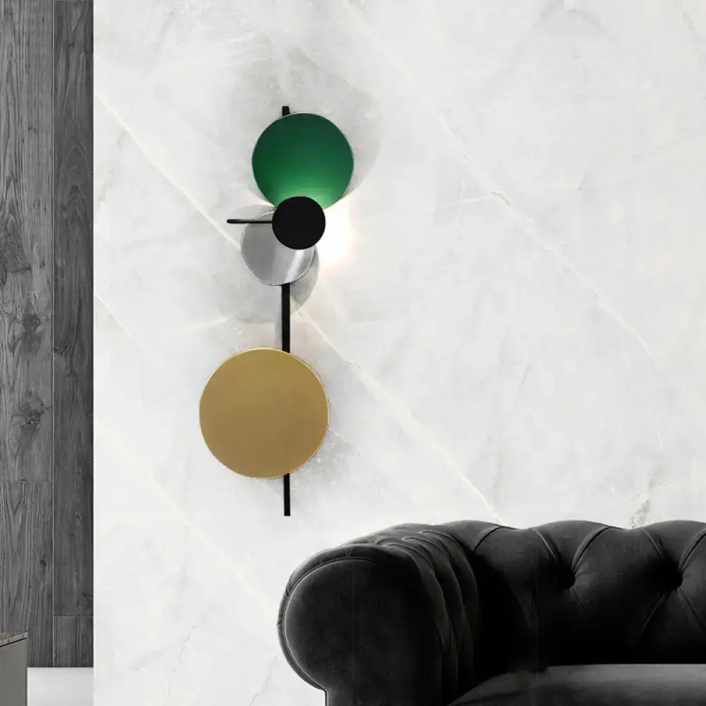 Modern wall light with three stacked circular shades in green black and gold metallic for white yellow bedroom use