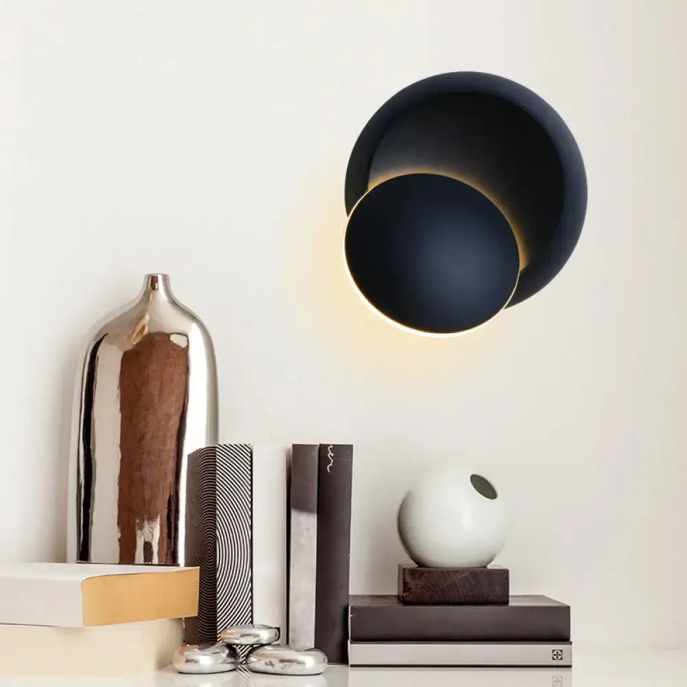 Modern black matte wall light with overlapping circular design providing white yellow led illumination for bedroom
