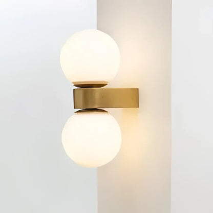 Modern wall lamp with two pink and orange glass ball led frosted shades on a brass decorbites glass ball base