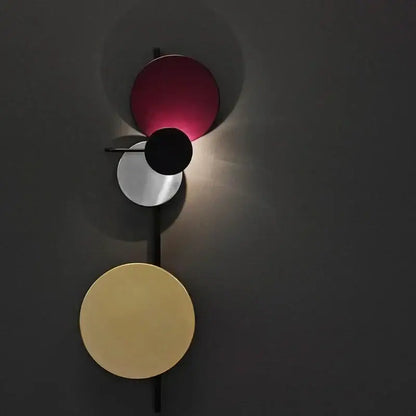 Modern pink silver and gold led wall lamp featuring three stacked circular shades in vibrant magenta black and gold tones