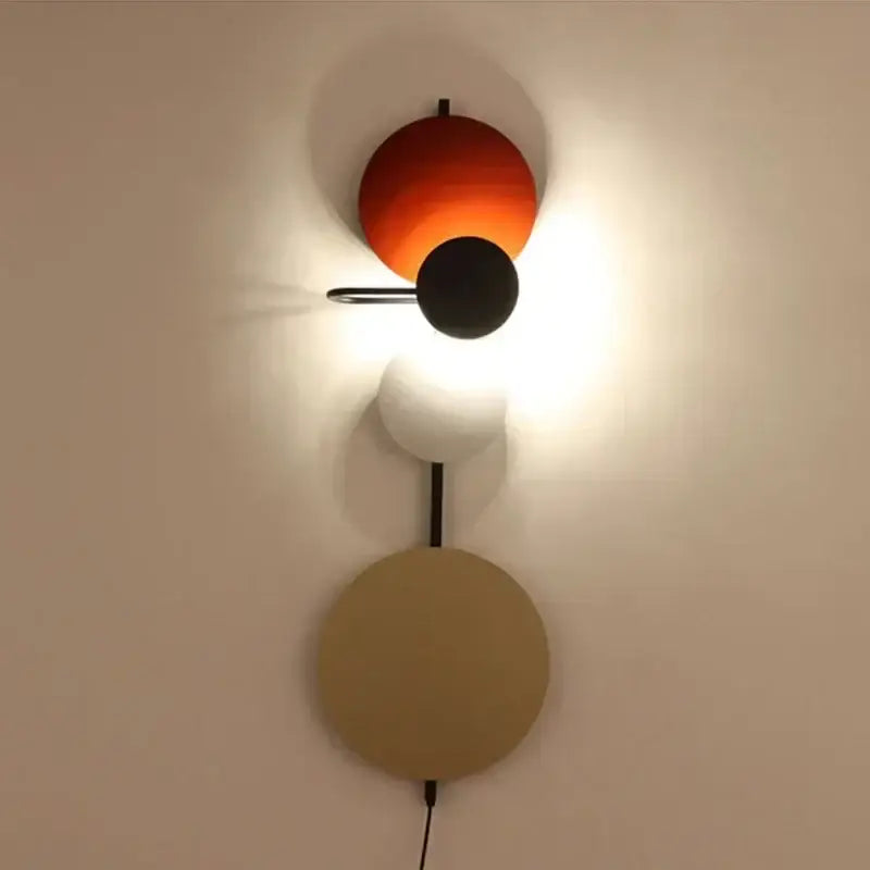 Modern pink silver and gold led wall lamp with three vibrant circular shades on a sleek metallic arm for bedroom decor