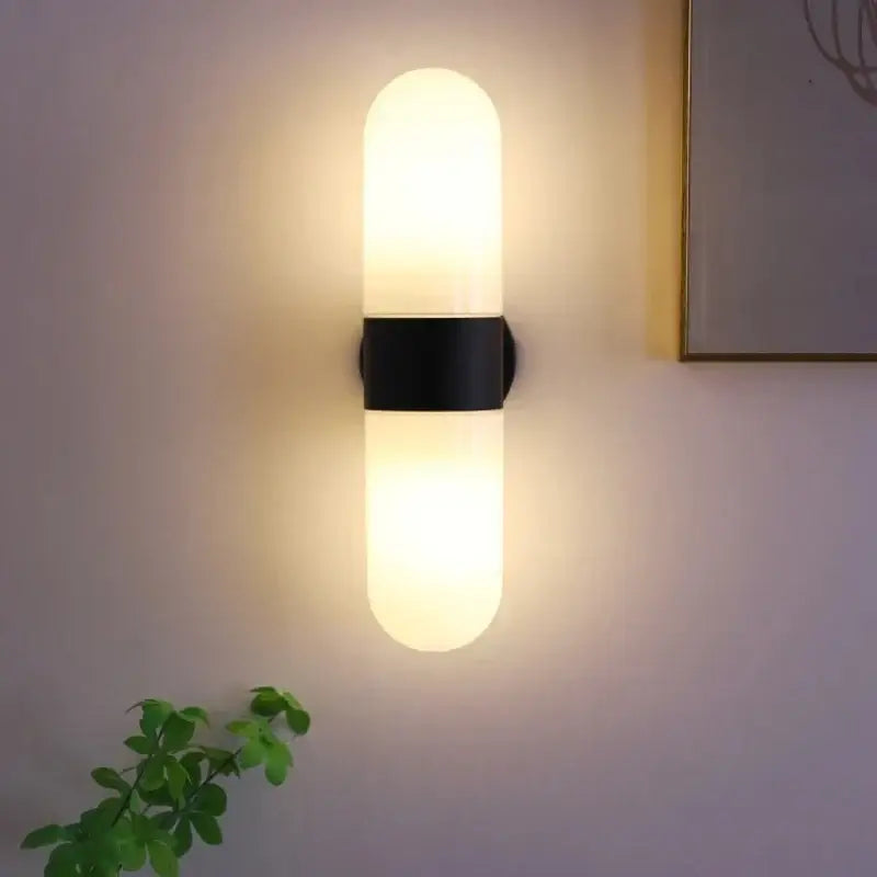 Modern minimalist vanity mirror light with frosted glass cylinder and black metal band for bathroom sconce illumination