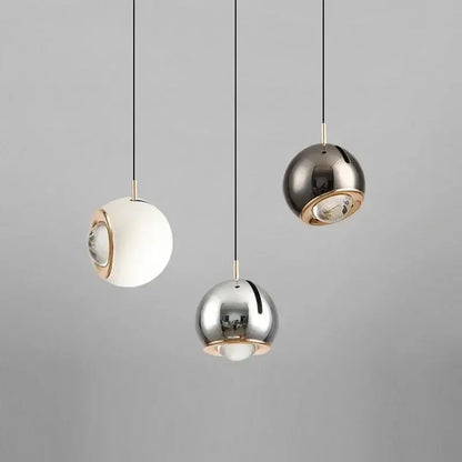 Three modern spherical pendant lights with polished metallic finish and gold-toned accents adjustable angle decorbites pendant light