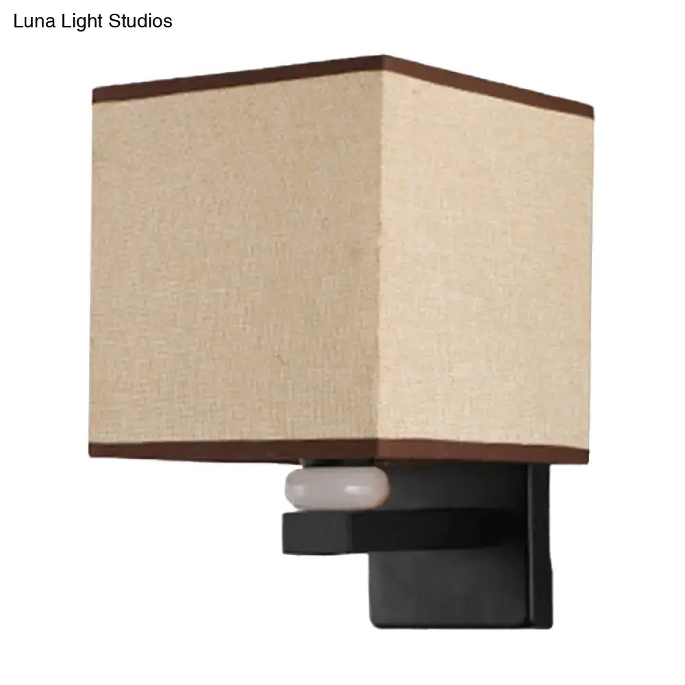 Modern rectangle fabric shade wall light with beige linen lampshade, dark brown trim, black metal base, and faux jade decor