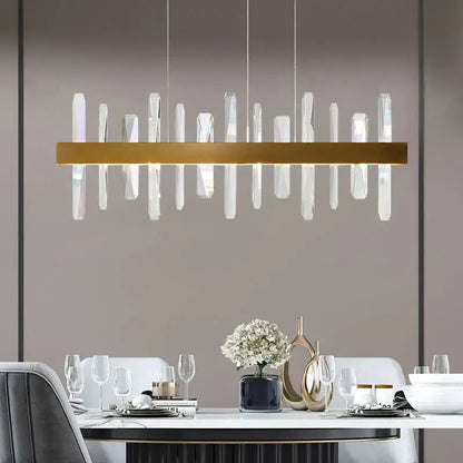 Modern rectangle gold crystal chandelier featuring clear vertical rods suspended from a central gold bar by DecorBites