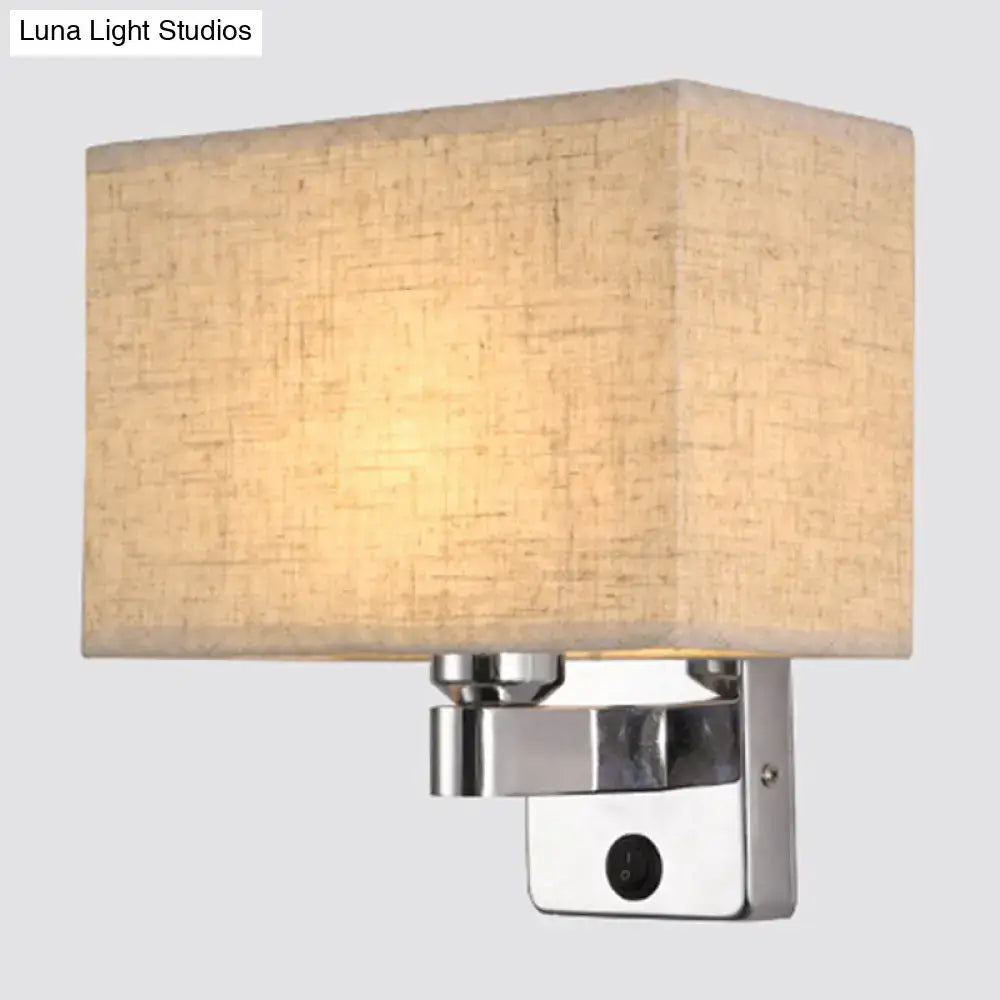 Modern rectangular chrome wall sconce with white beige fabric shade and polished metal base for bedroom lighting