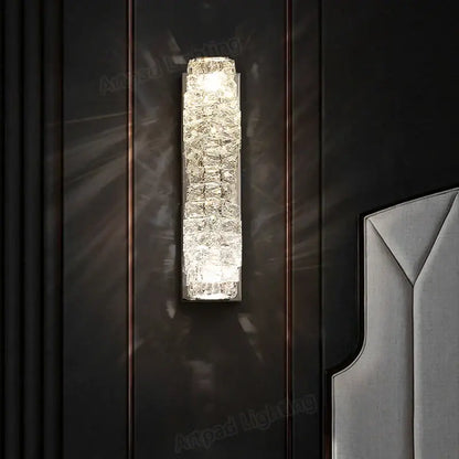 A modern rectangular crystal wall lamp with textured glass panels emitting warm light for bedroom decorbites wall lamp