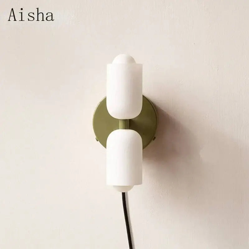 White matte double head glass wall sconce with sage green base featuring two stacked lamp heads for bedroom lighting
