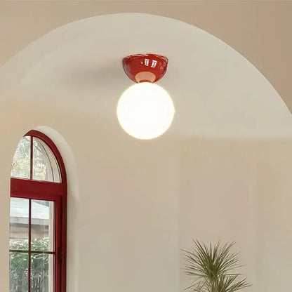 Modern red and white iron glass led ceiling light with a red ceramic base and round white globe bulb by decorbites iron glass