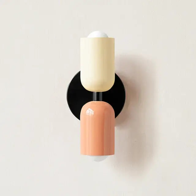 Cream and peach cylindrical led wall lamp with a black base for modern bedroom and living room decor