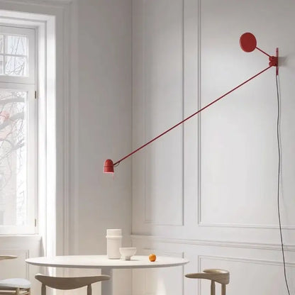 A sleek modern red and black swing arm wall sconce with an adjustable led circular head for bedroom lighting decorbites