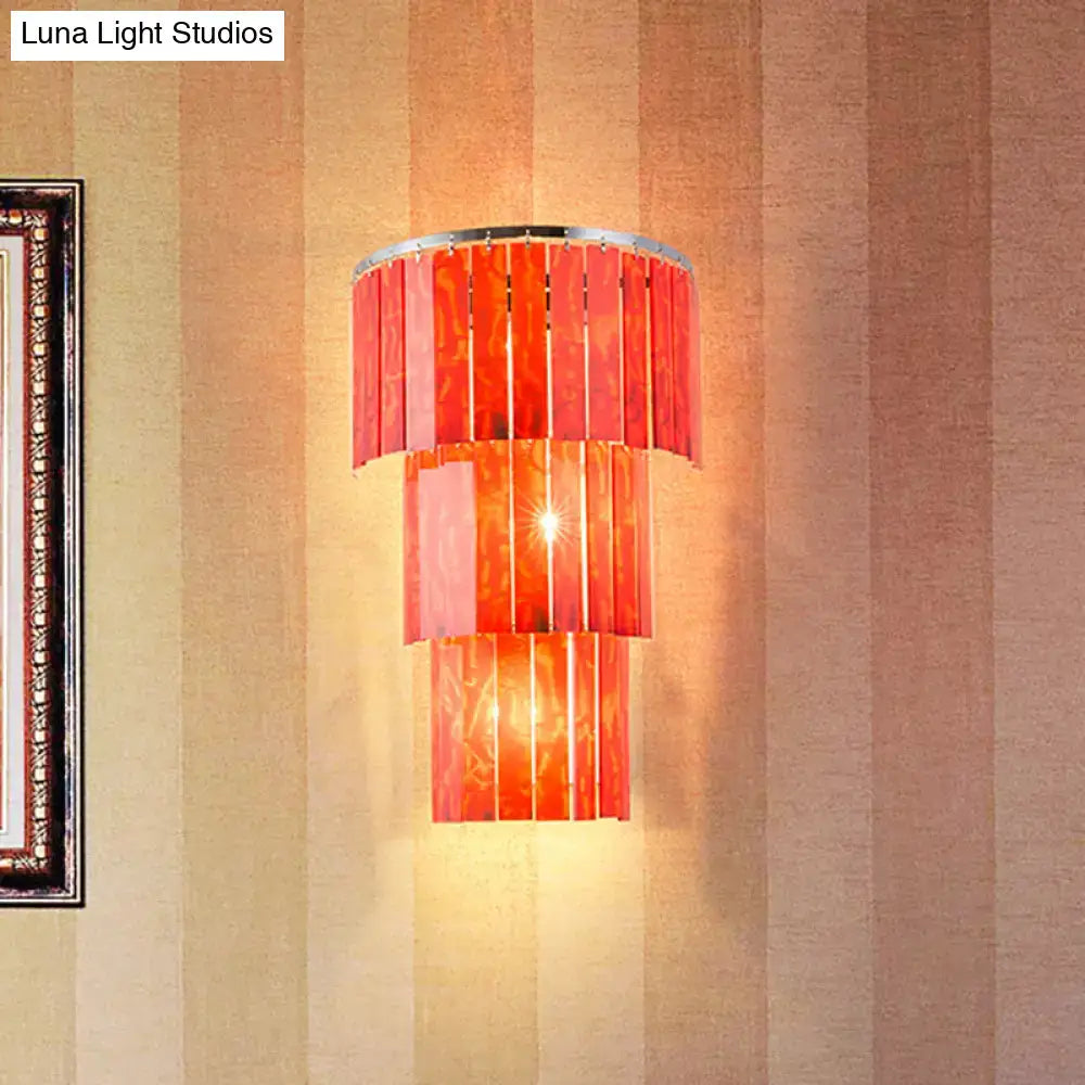Modern red prism wall mounted light with vibrant vertically slatted glass and polished chrome rim for living room