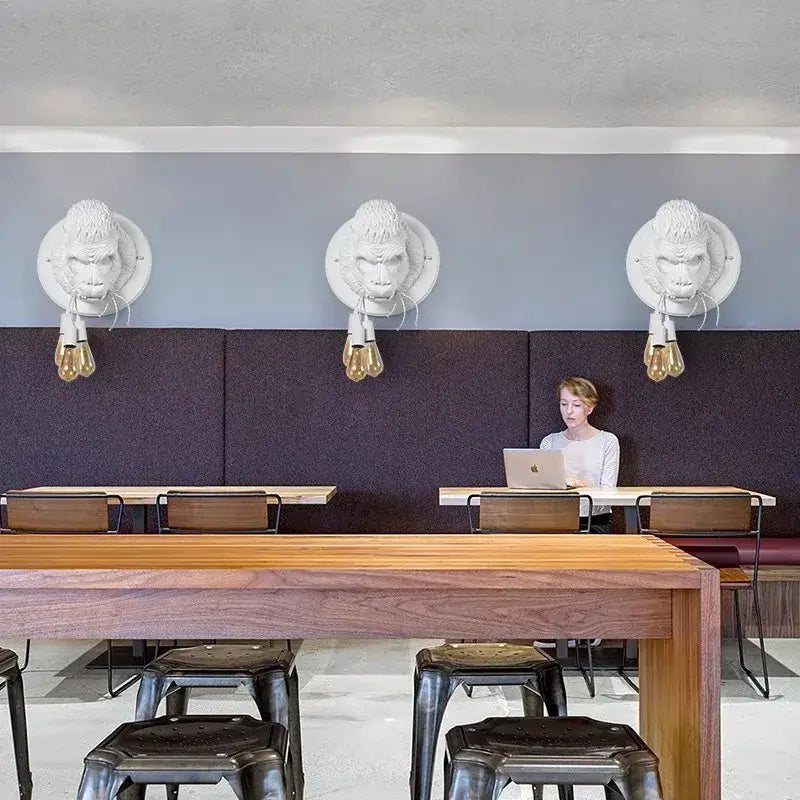 Modern retro dark gray gorilla resin wall lamp featuring white sculpted gorilla head sconces with exposed filament bulbs