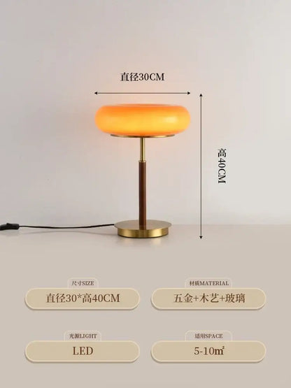 A warm amber glass table lamp with brass base and stem featuring modern retro decorbites gold lustre wood design