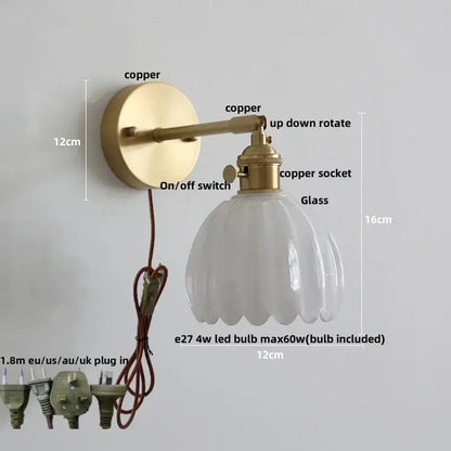 Vintage-style wall sconce with brass-finished copper arm, knob switch, and off-white fluted glass shade