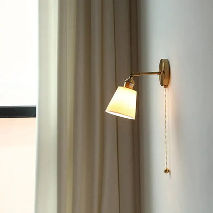 Modern ribbed ceramic led wall light with warm brass finish, off-white fabric shade, and adjustable arm for bedroom decorbites ceramic led wall