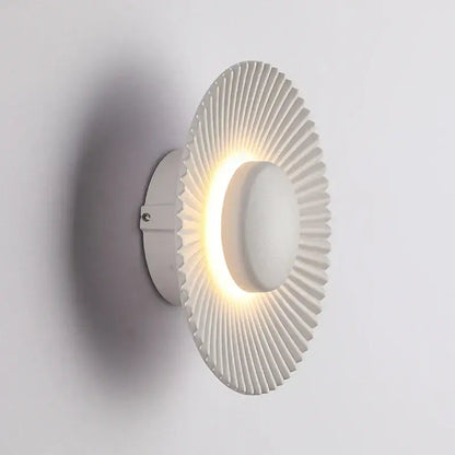 Modern ribbed circular white led wall lamp with radial ridges and illuminated center for bedroom lighting