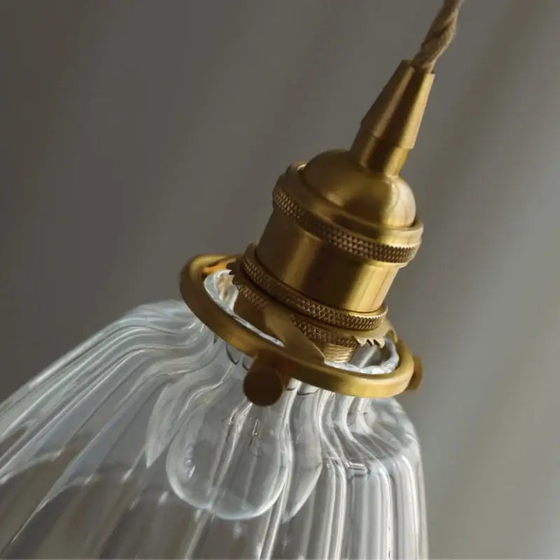 Brass-finished pendant light fixture with a clear ribbed glass shade for modern kitchen decorbites clear glass lighting