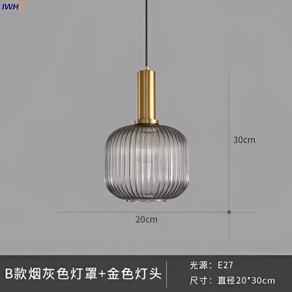 A modern glass pendant light with a smoked gray ribbed glass shade and brass stem for dining room use
