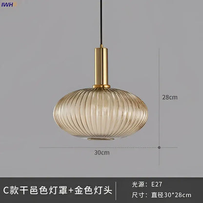 A sleek amber-tinted glass pendant light with vertical ridges and brass stem for modern dining room lighting