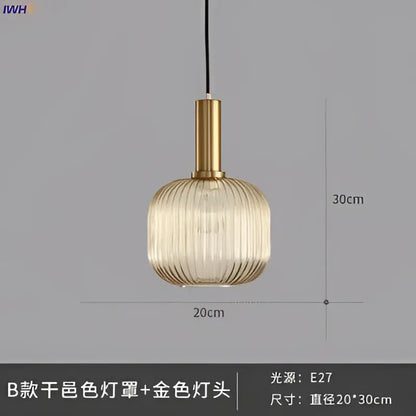 Modern ribbed glass pendant light with golden brass stem and translucent shade providing warm dining room illumination