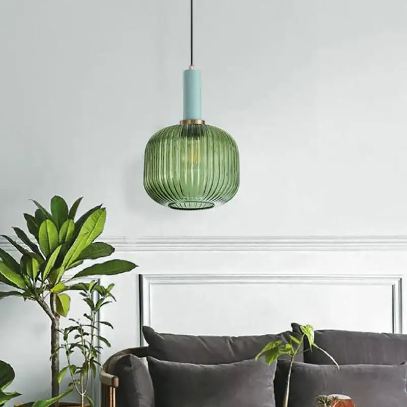 A modern green pumpkin glass pendant light with ribbed design teal top and brass accents for dining room decorbites pendant lights