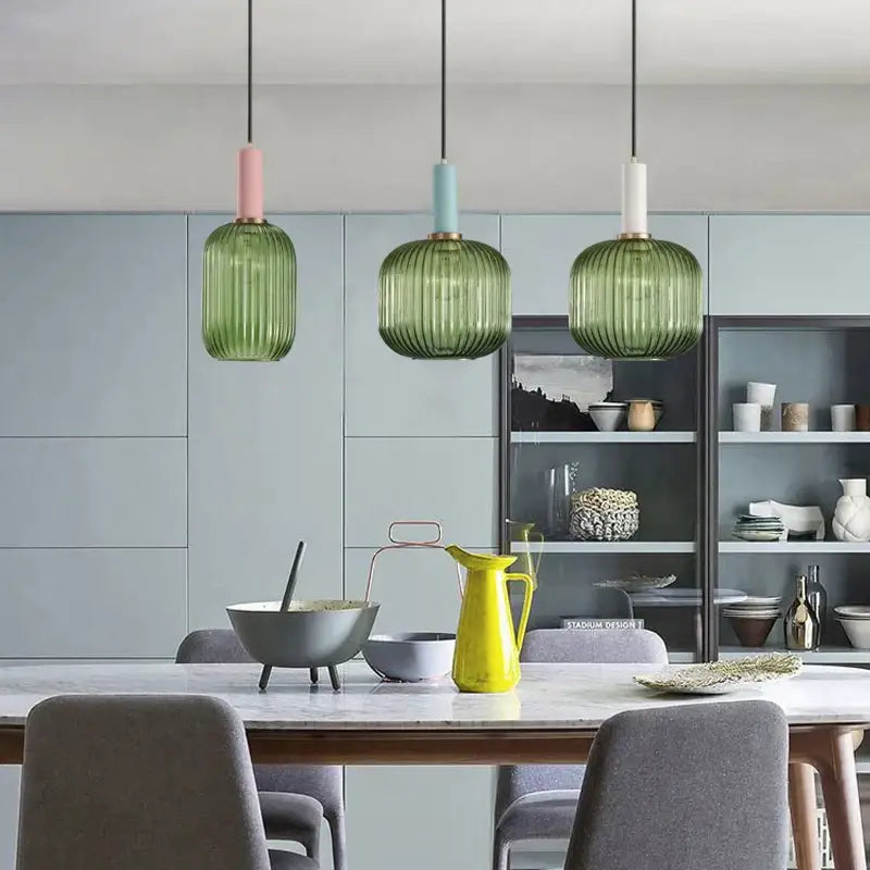 Three modern pendant lights feature ribbed green pumpkin glass shades with pastel tops for dining room decorbites green pumpkin