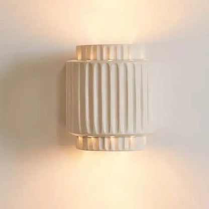 Modern ridged cream white resin wall lamp with vertical fluted ridges and warm diffused glow by decorbites cream white