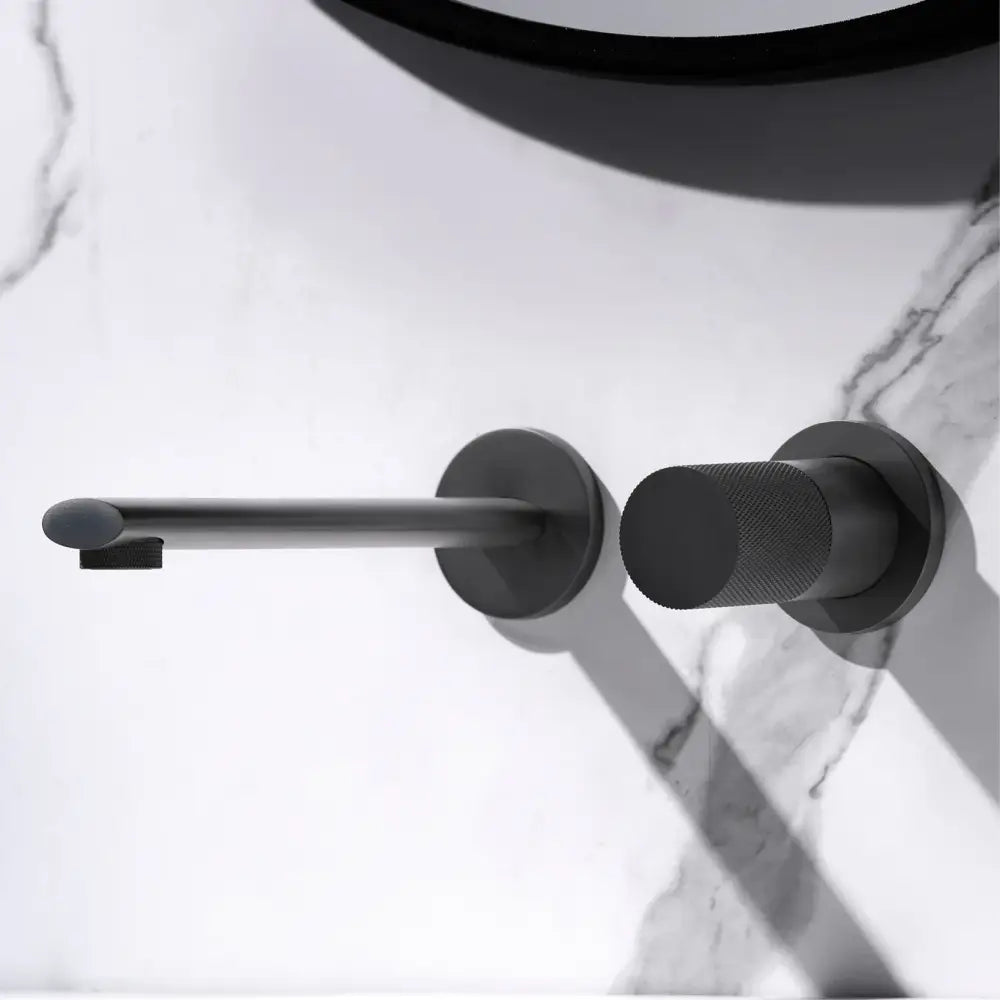 Black matte wall-mounted toilet paper holder with textured handle complementing modern rose gold aitana wall-mounted faucet with ceramic valve core