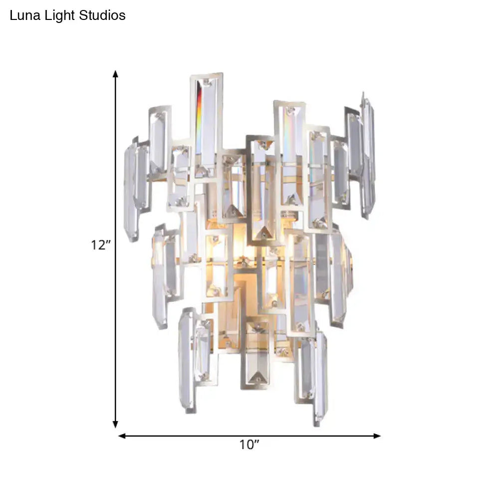 A modern rose gold wall lamp with a sleek silver frame and cascading clear crystal rectangular pieces for dining room