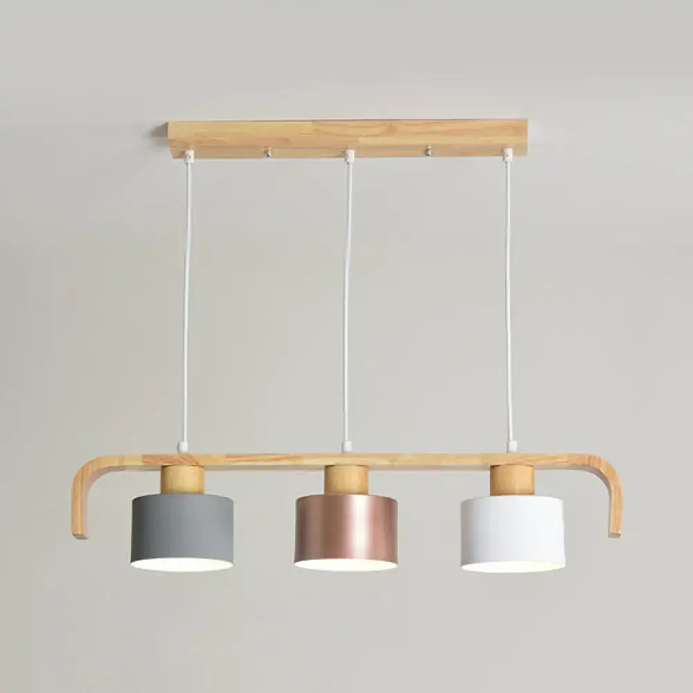 DecorBites modern rose gold drum island chandelier with three cylindrical shades in gray rose gold and white wood frame