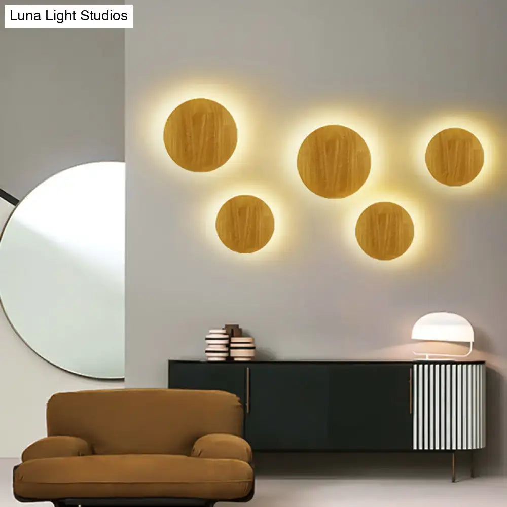 Five circular wooden led wall lighting sconces with warm glowing light for modern living room light fixture