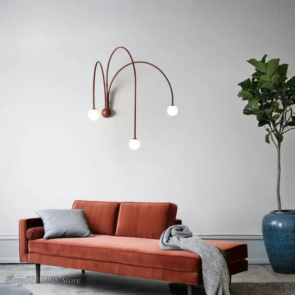 Rust-colored velvet sofa with gray throw pillow and blanket paired with modern decorbites branch glass wall lamps
