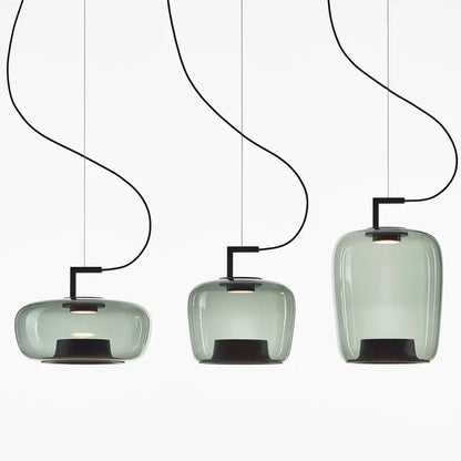 Three sleek translucent sage green brokis glass pendant lamps with black metal fixtures for dining room decorbites brokis glass