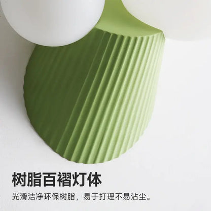 A sleek sage green decorbites cactus resin glass wall lamp with a ribbed eco-friendly resin base for bedrooms