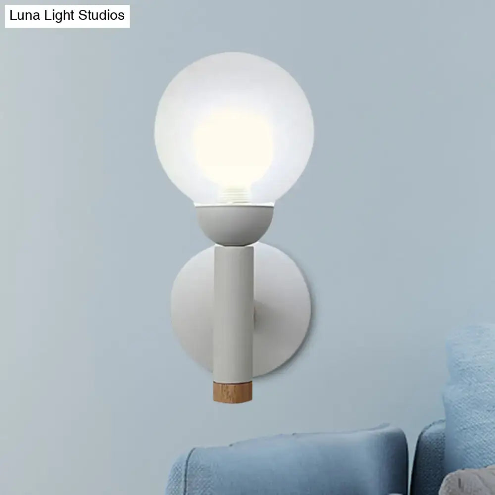 Minimalist macaron style torch wall light with frosted glass globe, matte white stem, and natural wood cap for bedroom use