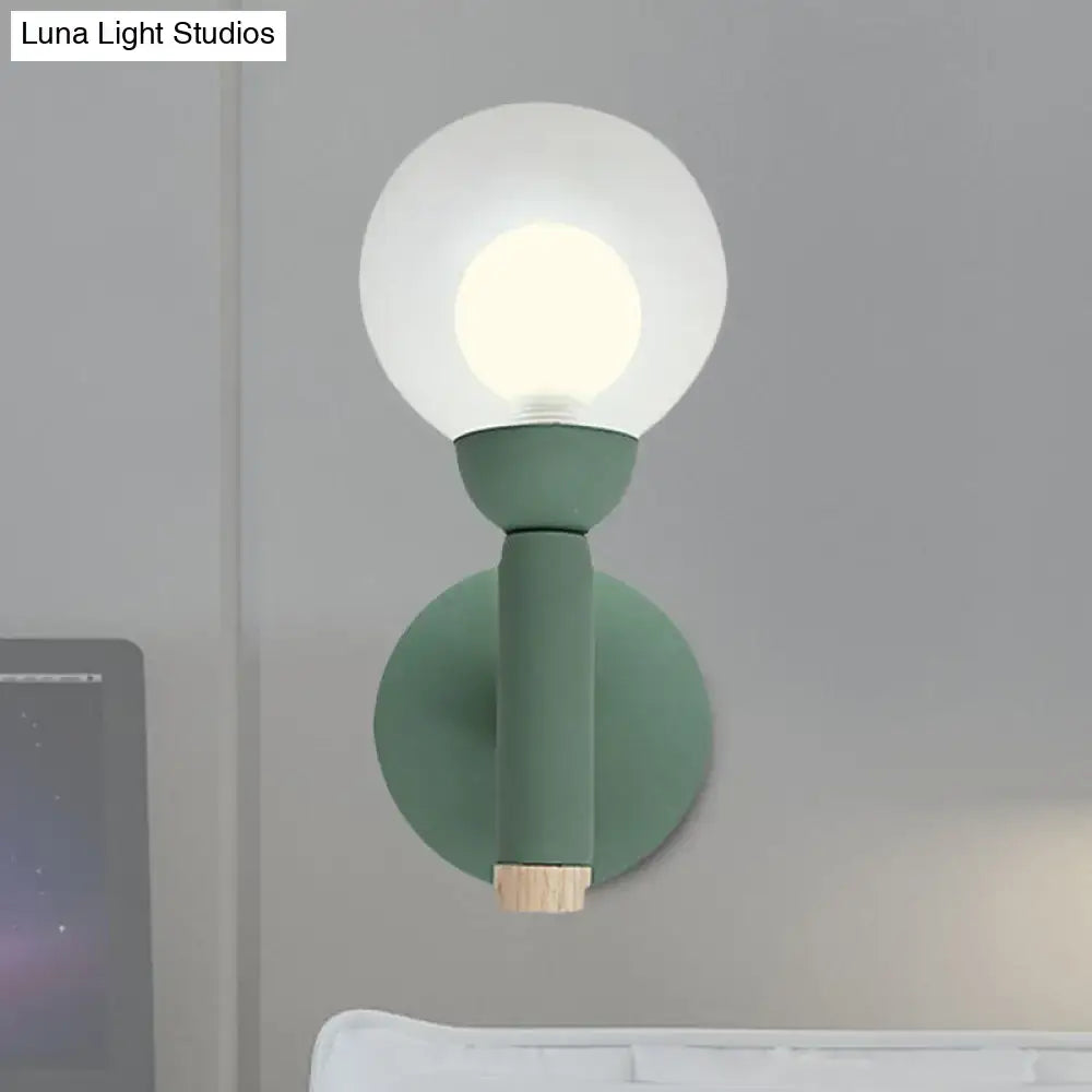 Modern sage green macaron style torch wall light with frosted glass globe and wooden accent for bedroom sconce use