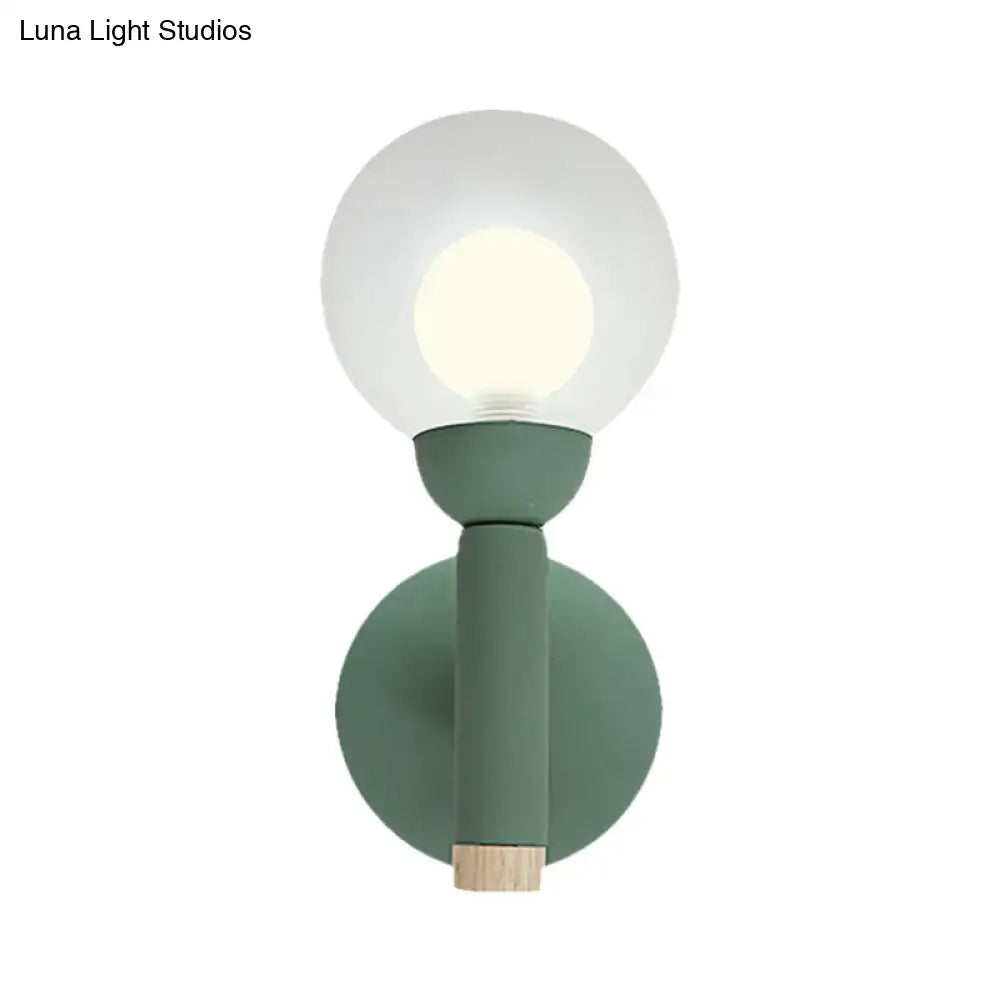 Modern sage green macaron style torch wall light with frosted glass globe and wooden accent for bedroom sconce