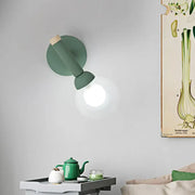 A sleek matte sage green macaron style torch wall light with wooden accent for modern bedroom sconce lighting