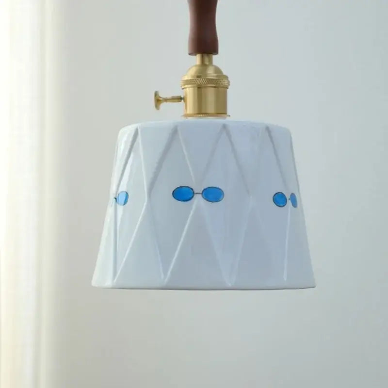 Modern scalloped floral ceramic led pendant light with white ceramic, blue oval sunglasses decals, and gold brass fixture