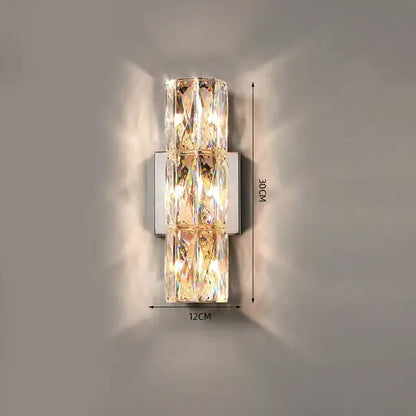 A modern decorbites crystal wall lamp with three stacked rectangular panels refracting warm golden light