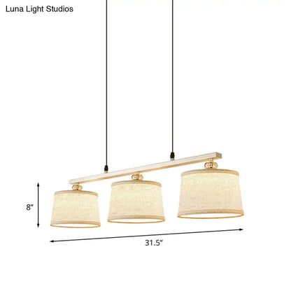 DecorBites modern three-light circle pendant light with white wood bar gold hardware and flaxen fabric shades for kitchen island