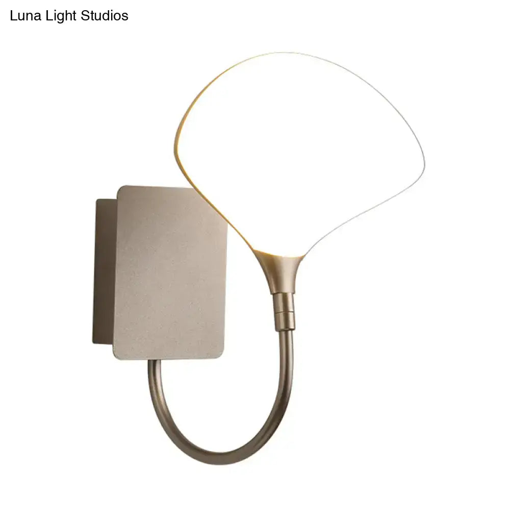 Modern silver arced arm wall lamp with acrylic shade featuring a brushed brass fan-shaped diffuser for bedroom lighting