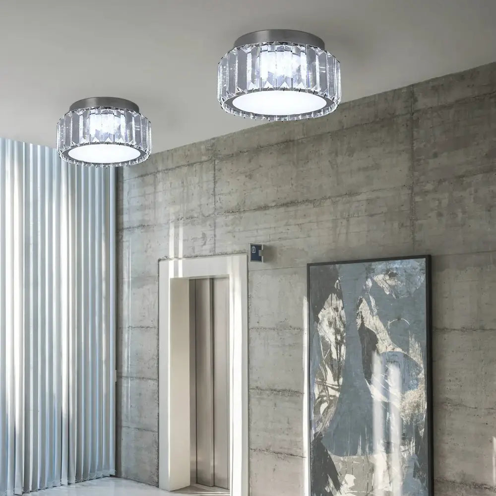 Two modern silver ceiling lamps with big crystal led circle fixtures and metallic rims for living room lighting