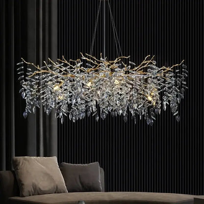 Luxurious gold-toned decorbites crystal pendant chandelier with intricate crystal leaves above a modern sofa