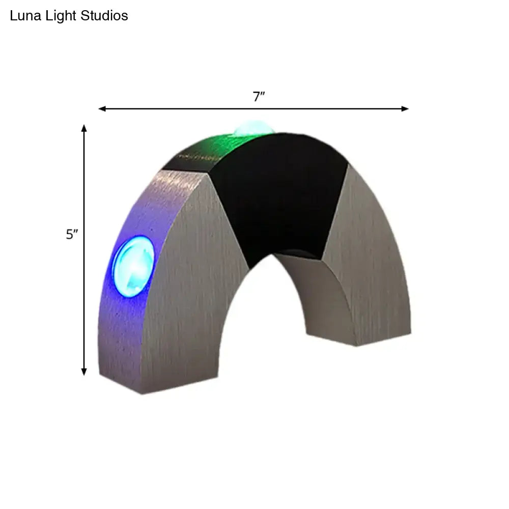 A sleek modern silver and black rgb color led wall light with brushed silver arch and blue green rgb color leds